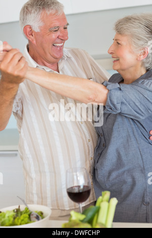 Gerne älteres paar tanzen, während eine Mahlzeit zuzubereiten Stockfoto