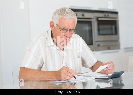 Konzentrierte sich senior Mann seine Rechnungen bezahlen Stockfoto