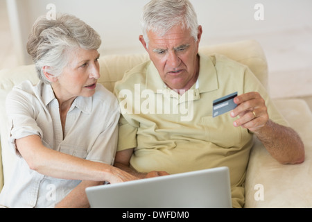 Älteres Paar mit dem Laptop zusammen einkaufen online Stockfoto