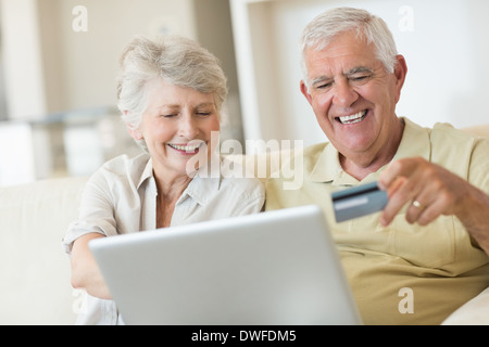 Älteres Paar mit dem Laptop zusammen einkaufen online Stockfoto
