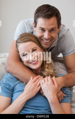 Junger Mann umfassenden Frau von hinten zu Hause Stockfoto