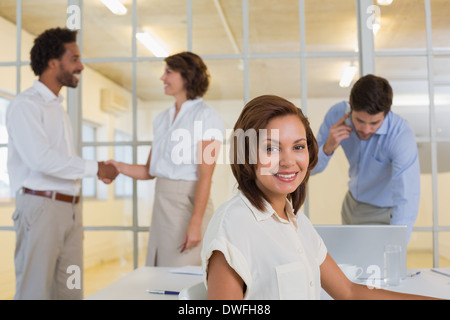 Lächelnd Geschäftsfrau mit Kollegen im Büro das Händeschütteln Stockfoto