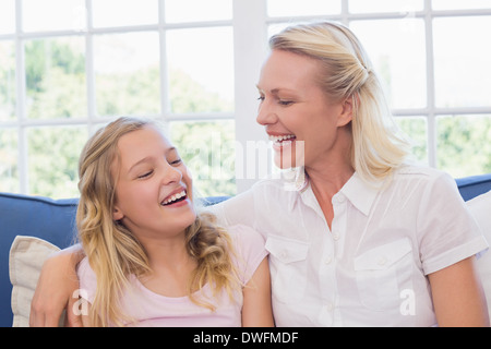 Mutter und Tochter lachend auf sofa Stockfoto