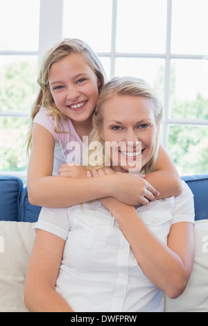 Süße Mädchen, die Mutter von hinten umarmen Stockfoto