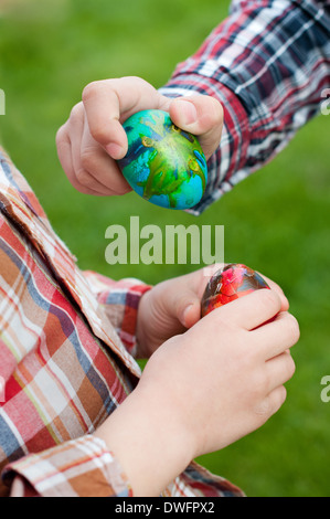 Zwei Kinderhände halten Ostereier Stockfoto