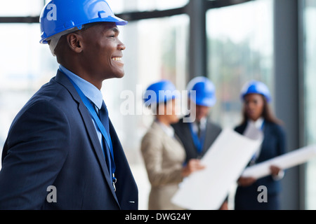lächelnde afrikanische amerikanische Bauarbeiter im Büro Stockfoto