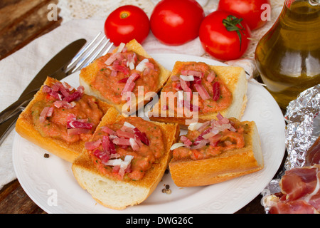 Teller mit Brot mit Tomaten und Schinken Stockfoto