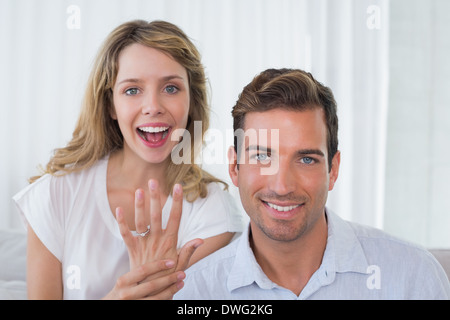 Frau zeigt Verlobungsring neben Mann Stockfoto