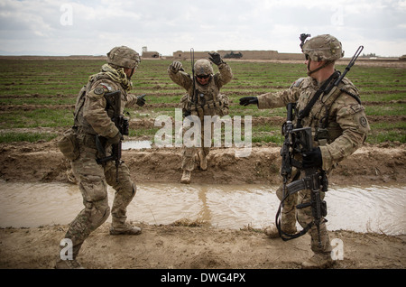 US-Armeesoldaten springen über eine Bewässerung Graben während einer Patrouille der Aufklärung im Rahmen der Operation Alamo Scout 12. Februar 2014 in der Provinz Kandahar, Afghanistan. Stockfoto