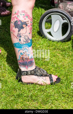 Junge britische Womans rechtes Bein mit großen Tattoo Asiatin. Es wird geschätzt, dass mehr als 40 % der Erwachsenen in Großbritannien eine Tattoo haben