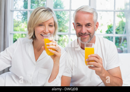 Älteres Paar mit Orangensaft zu Hause Stockfoto