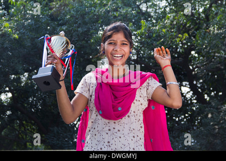 1 indische ländliche Mädchen stehend mit Trophäe Stockfoto