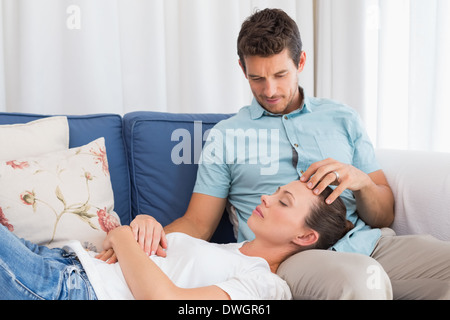 Entspannte Frau ruht auf mans Runde auf couch Stockfoto