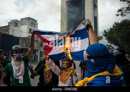 Caracas, Venezuela. 7. März 2014. Demonstranten brannte eine kubanische Flagge als Zeichen der Ablehnung des Einflusses der kubanischen Regierung in Venezuela während gewaltsame Auseinandersetzungen in Caracas fortfahren. Bildnachweis: Carlos Becerra/NurPhoto/ZUMAPRESS.com/Alamy Live-Nachrichten Stockfoto