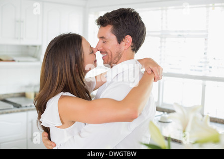Junges Liebespaar umarmt in Küche Stockfoto