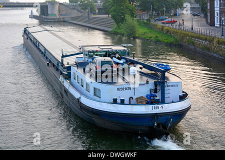 Maastricht River Maas (Maas) Besatzungsmitglieder befördern Frachtwagen auf einem großen beladenen Motorschiff, das entlang der städtischen Flussstraße fährt Stockfoto