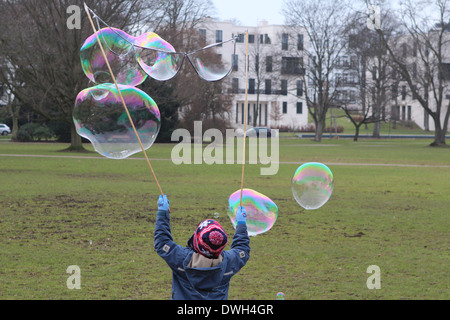 kleiner Junge startet Seifenblasen Stockfoto