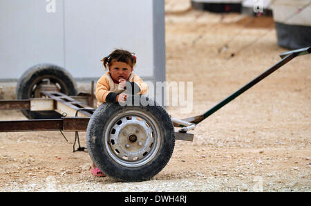 Amman, Jordanien. 8. März 2014. Ein syrischer Kind ruht auf einem Wohnwagen Rad Zaatari Flüchtlingslager in Mafraq Stadt, Jordanien, auf 8. März 2014. Mehr als 90.000 syrische Flüchtlinge befinden sich derzeit in Zaatari. © Mohammad Abu Ghosh/Xinhua/Alamy Live-Nachrichten Stockfoto