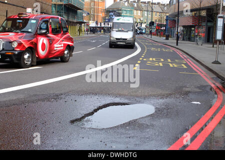 Schlagloch. . London, UK. 8. März 2014.  Ein großes Schlagloch in der Straße war voller Wasser in der Nähe von Finsbury Park, North London. Bild: Paul Marriott Fotografie/Alamy Live-Nachrichten Stockfoto