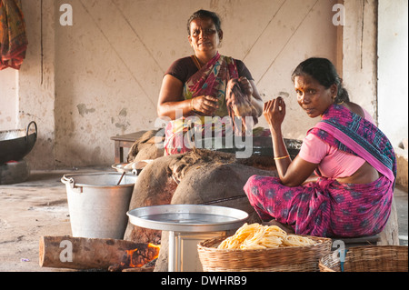 Indien-Tamil Nadu Chettinad Karakaikudi zwei Damen Frauen Frauen Sari Saree Tiefe Pommes Kuchen in heißem Öl schwarz Wok Familienbäckerei Stockfoto