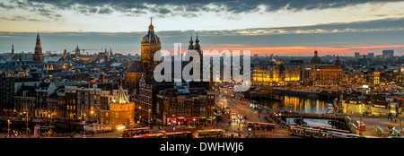 Panoramablick über Amsterdam Skyline bei Sonnenuntergang mit Lichter Straßenbahnen und berühmte Gebäude Stockfoto