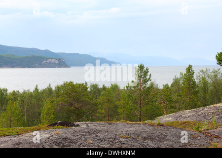 Felsige Küste und die Berge in der Ferne, Norwegen Stockfoto