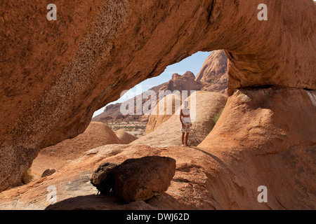 Tourist am Felsbogen in der Nähe von Granit Berg Spitzkoppe, Namibia, Afrika Stockfoto