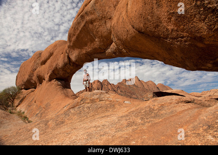 Tourist am Felsbogen in der Nähe von Granit Berg Spitzkoppe, Namibia, Afrika Stockfoto