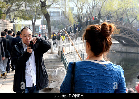 Jinan, China Shandong Provinz. 10. März 2014. Eine Mädchen posiert für Fotos im Huancheng Park in Jinan, der Hauptstadt der ostchinesischen Provinz Shandong, 10. März 2014. Wie Temperatur schnell in Jinan kletterte, war Frühjahr sehr viel in der Luft am Montag. © Feng Jie/Xinhua/Alamy Live-Nachrichten Stockfoto