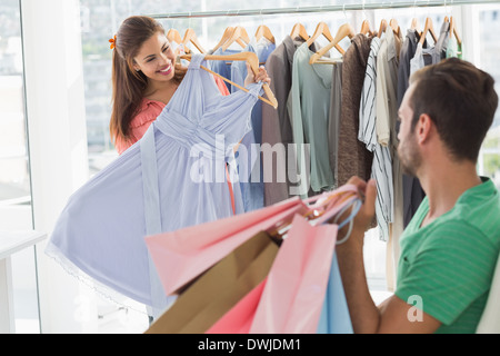Mann mit Einkaufstüten, während die Frau eine Kleid auswählen Stockfoto