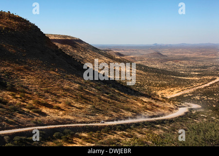 Fahrzeug auf einer abgelegenen einsamen Straße über den Grootberg Pass in der Halbwüste Damaraland in Namibia. Stockfoto