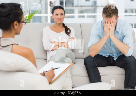 Unglückliche paar sitzt auf Sofa in Therapiesitzung Stockfoto