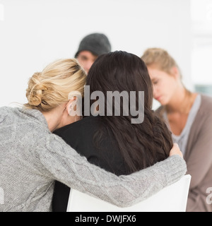 Frauen in Reha Gruppe umarmen Stockfoto