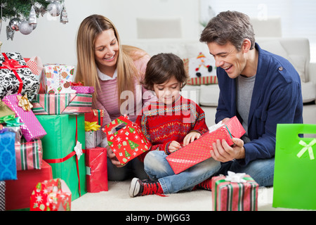Eltern geben Weihnachtsgeschenk an Sohn Stockfoto