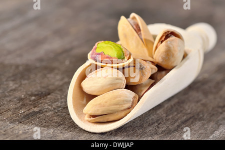 einem Holzlöffel von rohe Pistazien auf einem alten hölzernen Hintergrund Stockfoto