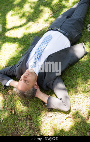 Geschäftsmann entspannend auf Rasen Stockfoto