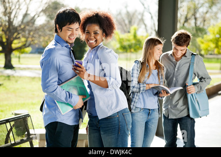 Student mit Handy Freund am Campus Stockfoto