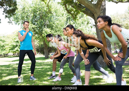 Trainer, Pfeifen, während Läufer Rennen bereit Stockfoto