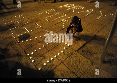 Kuala Lumpur, Malaysia. 10. März 2014. Malaysischen ethnischen chinesischen Mädchen Lichter Kerzen während eine Mahnwache für die fehlenden Malaysia Airlines-Passagiere in Kuala Lumpur, Malaysia. Malaysia Airlines Flug MH370 mit 239 Menschen an Bord ging Anfang März 8, während auf dem Weg nach Peking, China fehlt. Malaysia Suche und Rettung Betrieb um die fehlenden Malaysia Airlines Passagier-Jet mit 239 Personen an Bord zu finden erweitert wird, wie der dritte Tag der Suche keine Ergebnisse gebracht, sagte ein senior malaysischen Luftfahrt-Beamter. Bildnachweis: Firdaus Latif/NurPhoto/ZUMAPRESS.com/Alamy Live-Nachrichten Stockfoto