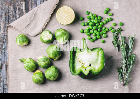 Draufsicht auf die Sammlung von grünem Gemüse Rosenkohl, Paprika, Erbsen, Kalk und Rosematy auf alten Holztisch Stockfoto