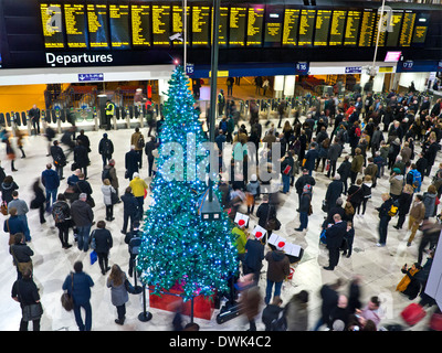WATERLOO STATION CONCOURSE CHRISTMAS PENDLER erhöhte Ansicht der belebten Concourse und Abfahrten Bord an der Waterloo Station an Weihnachten London SE1 Stockfoto