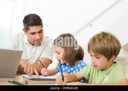 Vater mit Laptop Kinder zeichnen Stockfoto