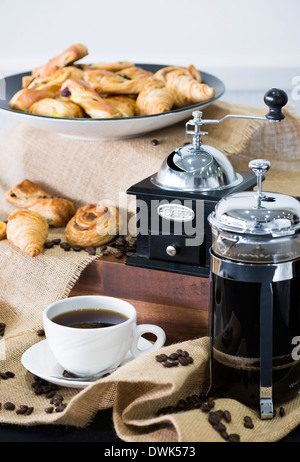 Vintage Kaffee Schleifmaschine mit gebrühtem Kaffee und eine Tasse. Stockfoto