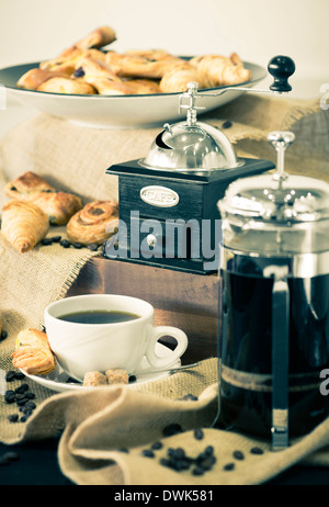 Vintage Kaffee Schleifmaschine mit gebrühtem Kaffee und eine Tasse. Stockfoto