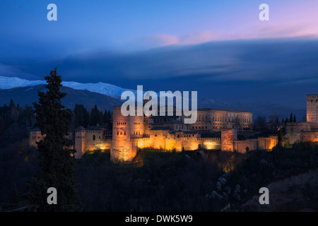 Die Alhambra in der Dämmerung: Der klassische Blick von der Plaza Mirador de San Nicolás in El Albaicín auf dem Hügel gegenüber dem Palast, Granada, Spanien Stockfoto