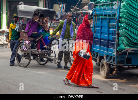 Agra, Indien. Straßenszene, Kinari Basar Bereich. Frauen in einer Rikscha fahren. Frau im Sari zu Fuß. Stockfoto