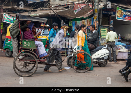 Agra, Indien. Straßenszene, Kinari Basar Bereich. Wandern Sie eine Rikscha mit drei Passagieren. Stockfoto