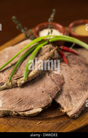 in Scheiben geschnitten Kochfleisch Präsentation auf Holzbrett Stockfoto