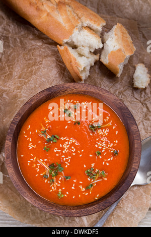 Tomaten Suppe pürieren in Holzschale auf zerkleinerte braune Papiertüte Stockfoto