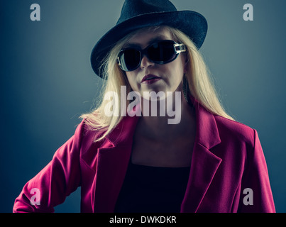 Urbane Reife Frau trägt eine Sonnenbrille und Hut, Studio gedreht Stockfoto